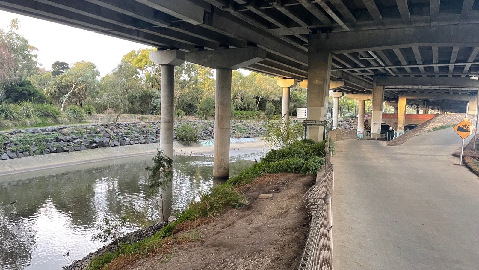 a river flowing beneath a highway underpass