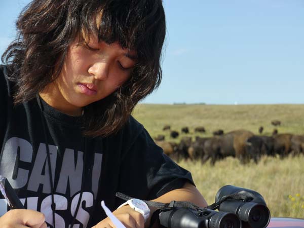 Gustavus Adolphus College student Mary Joy Sun records bison observations on the Ordway Prairie. Photo: Matt Miller/TNC