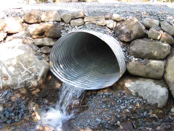 A poorly designed road culvert for fish. Note that the pipe is above the stream, essentially cutting it off for native fish. Photo: Ausable River Association