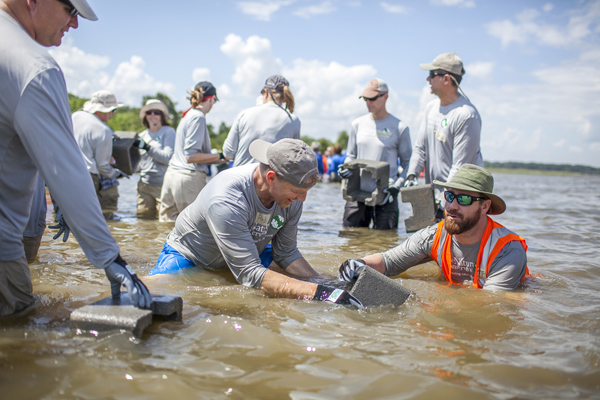 TNC staff work together with CH2M HILL partners to build five oyster reef structures at Arlington Cove in Mobile Bay, Alabama. Photo: Erika Nortemann/TNC