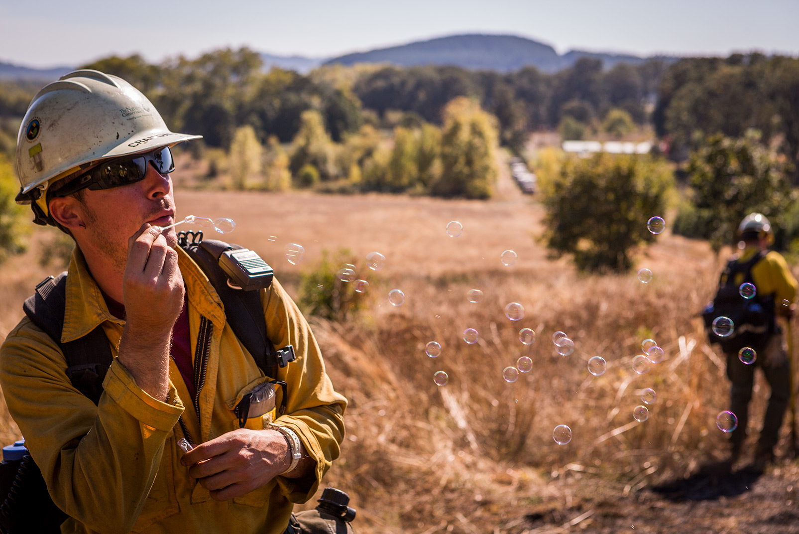 The conditions, including wind speed and direction, must be just right before conducting a burn, Houston says. Here Module Leader Jeff Crandall uses bubbles to gauge wind direction and smoke dispersion. Photo © Jason Houston