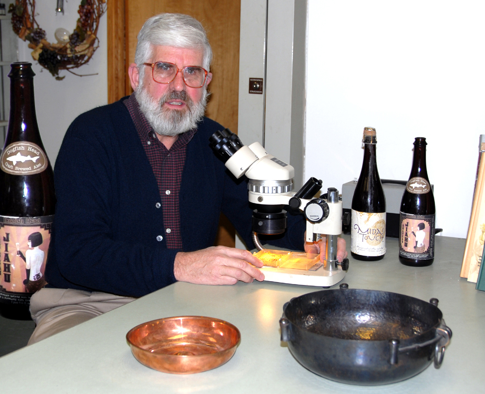 Patrick McGovern, Scientific Director of Biomolecular Archaeology Laboratory at the Penn Museum, examines a sample of the "King Midas" beverage residue under a microscope. Photo © Pam Kosty / Wikimedia through a Creative Commons license