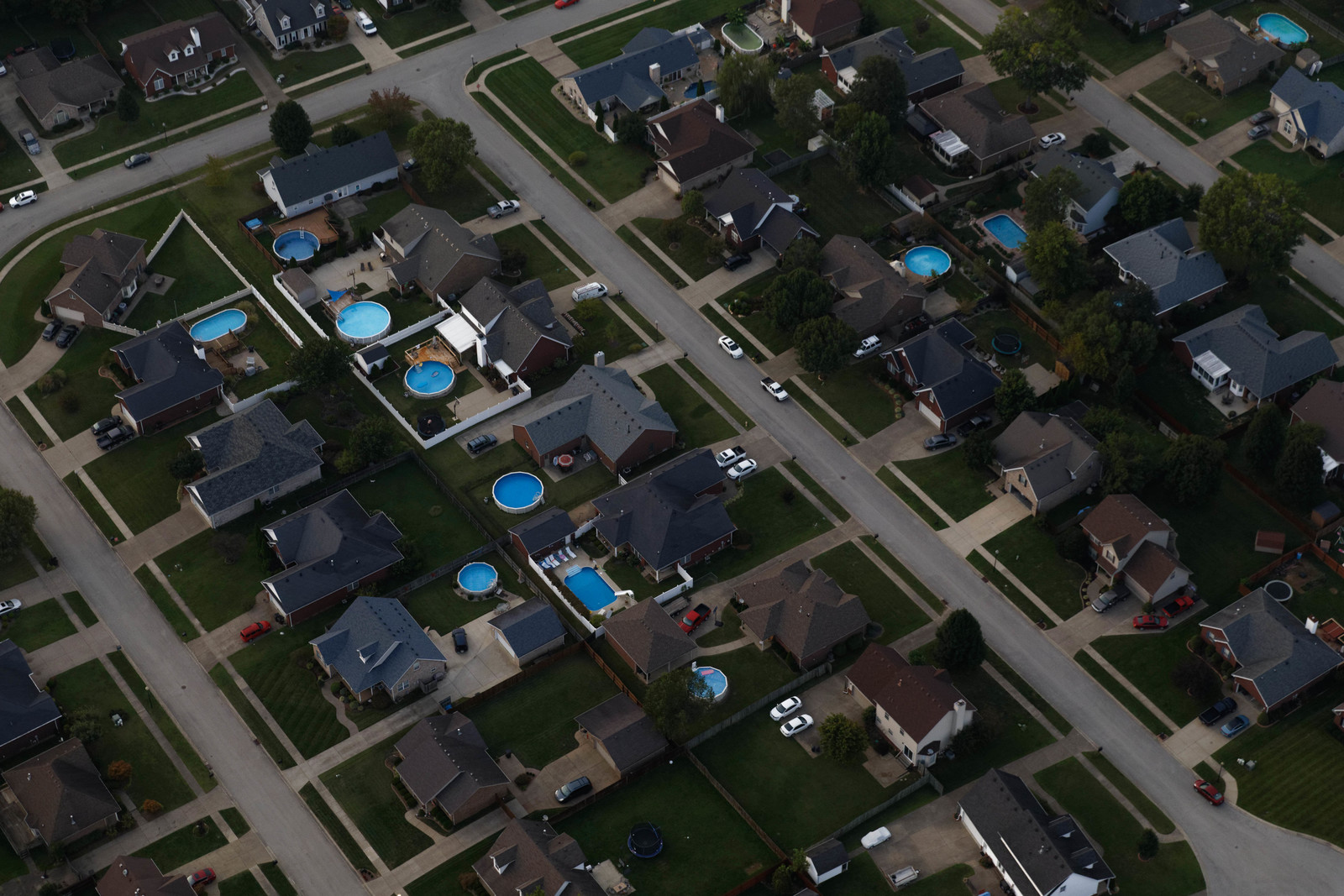 aerial image of housing development showing backyards and a few swimming pools. 