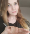 woman holds a small tarantula in her hand