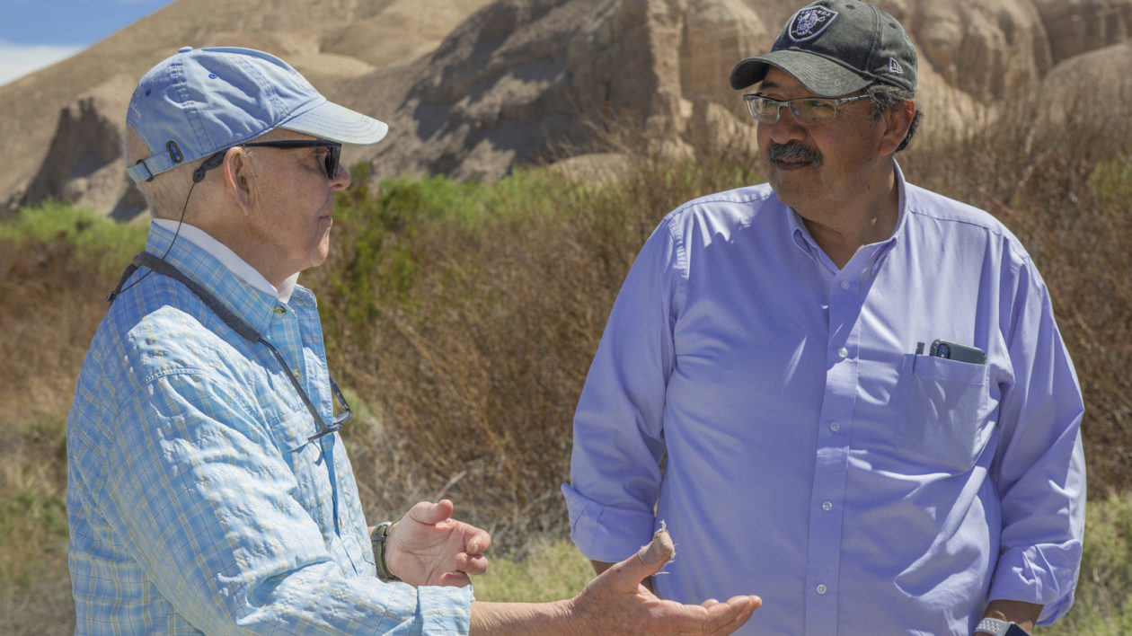 two men talking in the desert