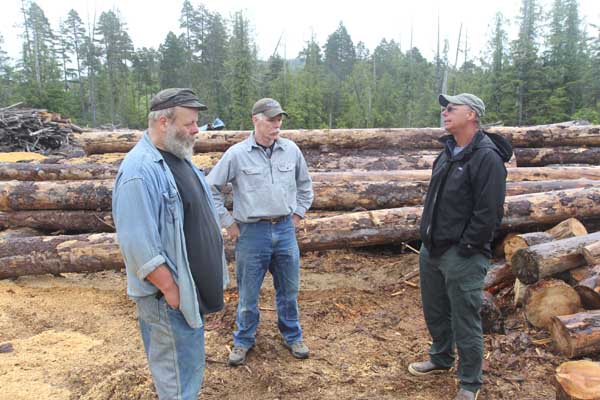 (Left to right) Sawmill owner Mel Cook discusses young growth wood with Conservancy staffers Michael Kampnich and Keith Rush. Photo: Matt Miller/TNC