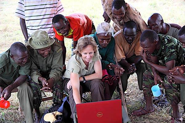 A crowd gathers around Dr. Juliet King to enjoy camera trap photos from the previous night.