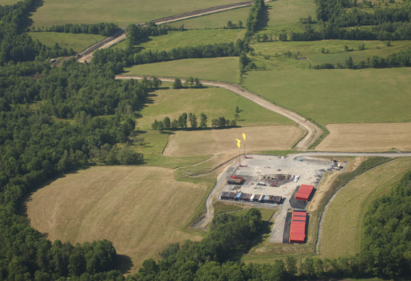 Aerial photogaph showing gas well head, gas flares, fracking chemical storage containers and pipeline route at a natural gas well and fracking site situated in rural forest and farmland in north-eastern Pennsylvania. Photo: © Mark Godfrey/TNC