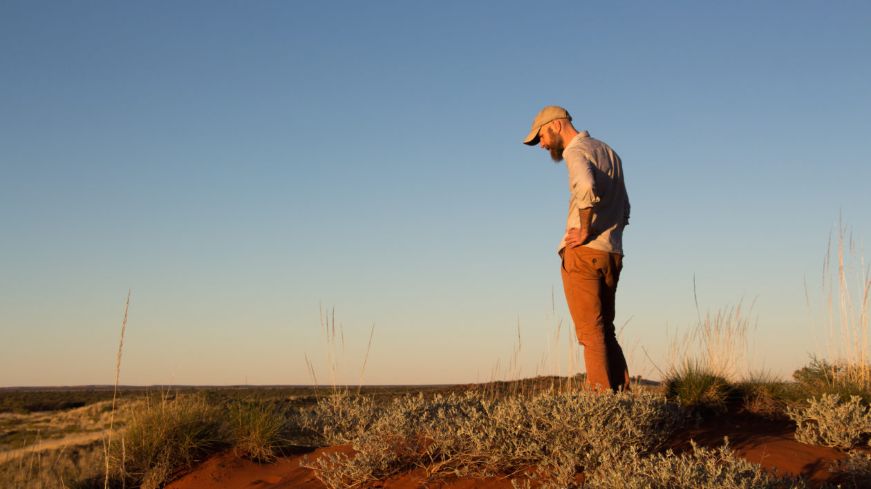 Eddie Game looks for emu tracks on the crest of a dune. Photo © The Nature Conservancy (Justine E. Hausheer) 