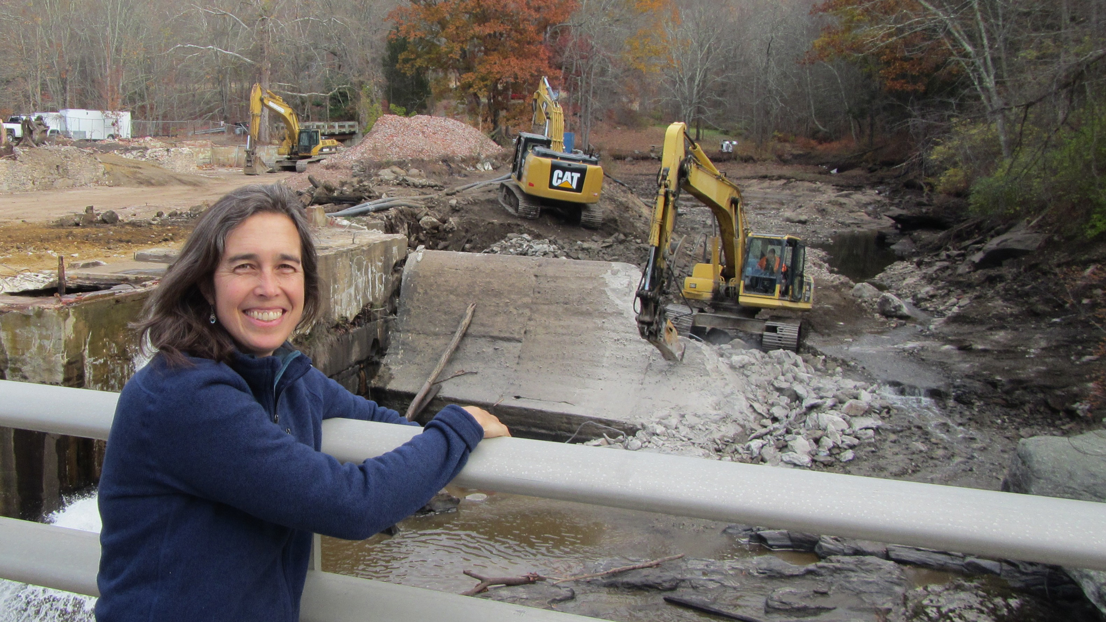 TNC's Sally Harold at the Norton Paper Mill Pond dam, removed last fall on the Jeremy River in Colchester, CT. The Jeremy and the Blackstone come together to form the Salmon River. The removal of this dam (CT’s biggest dam removal to date) opened up 17 miles of high-quality habitat upstream. Photo © Steve Gephard