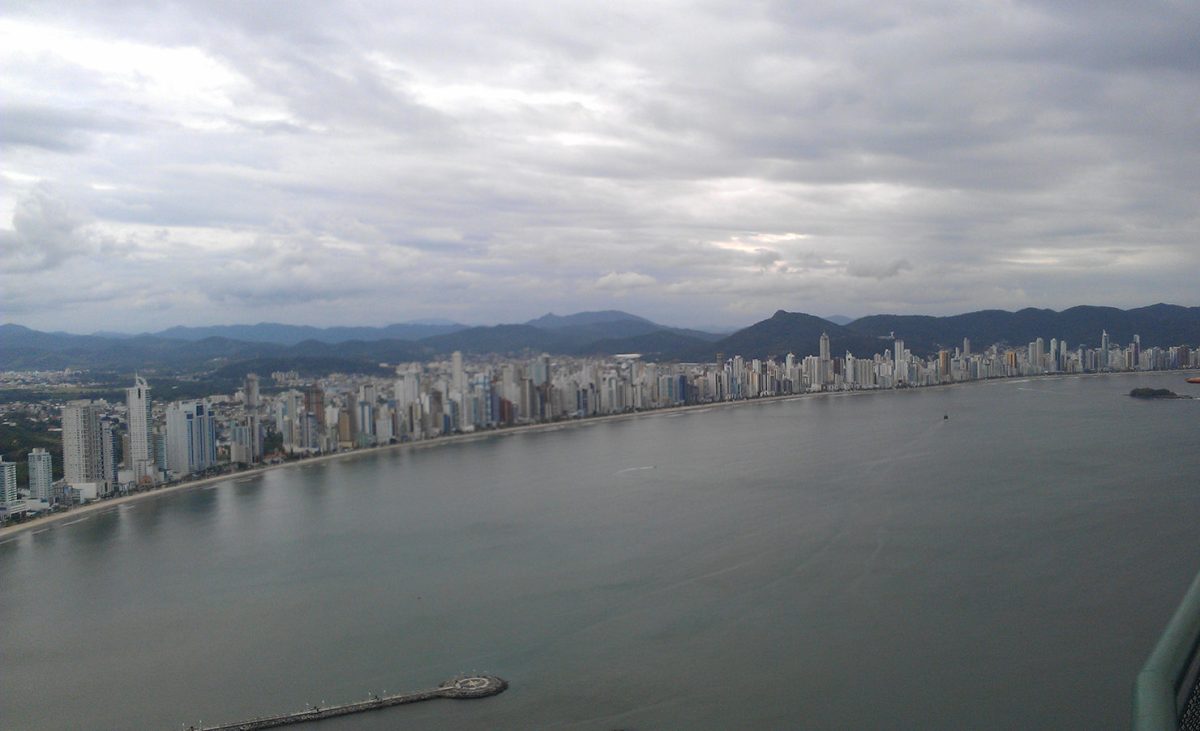 city on the edge of a bay, skyscrapers with mountains in the background