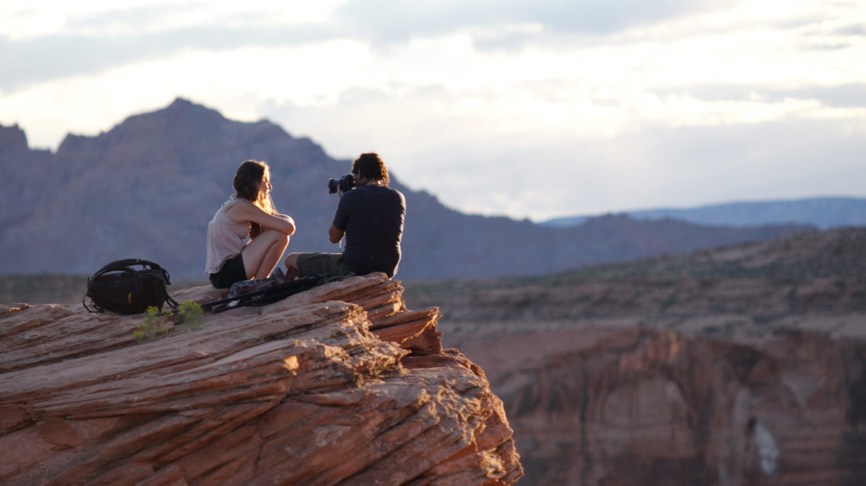 two people on cliff with camera