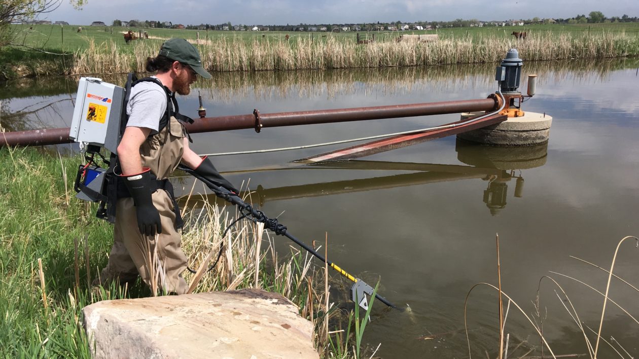 man with pole in water