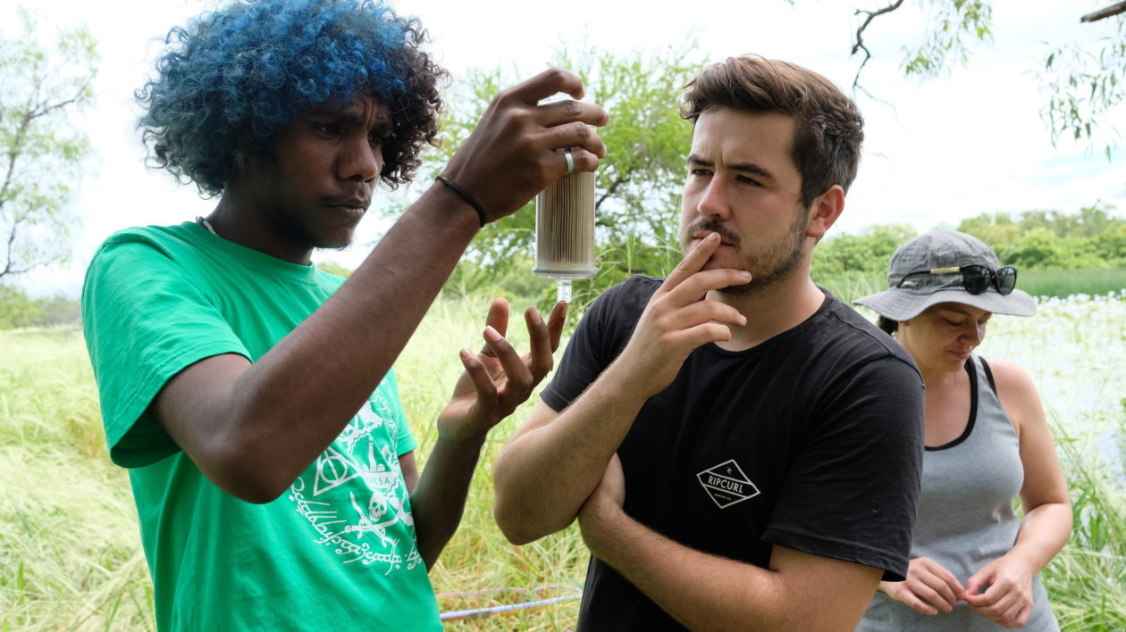 two young men looking at beaker