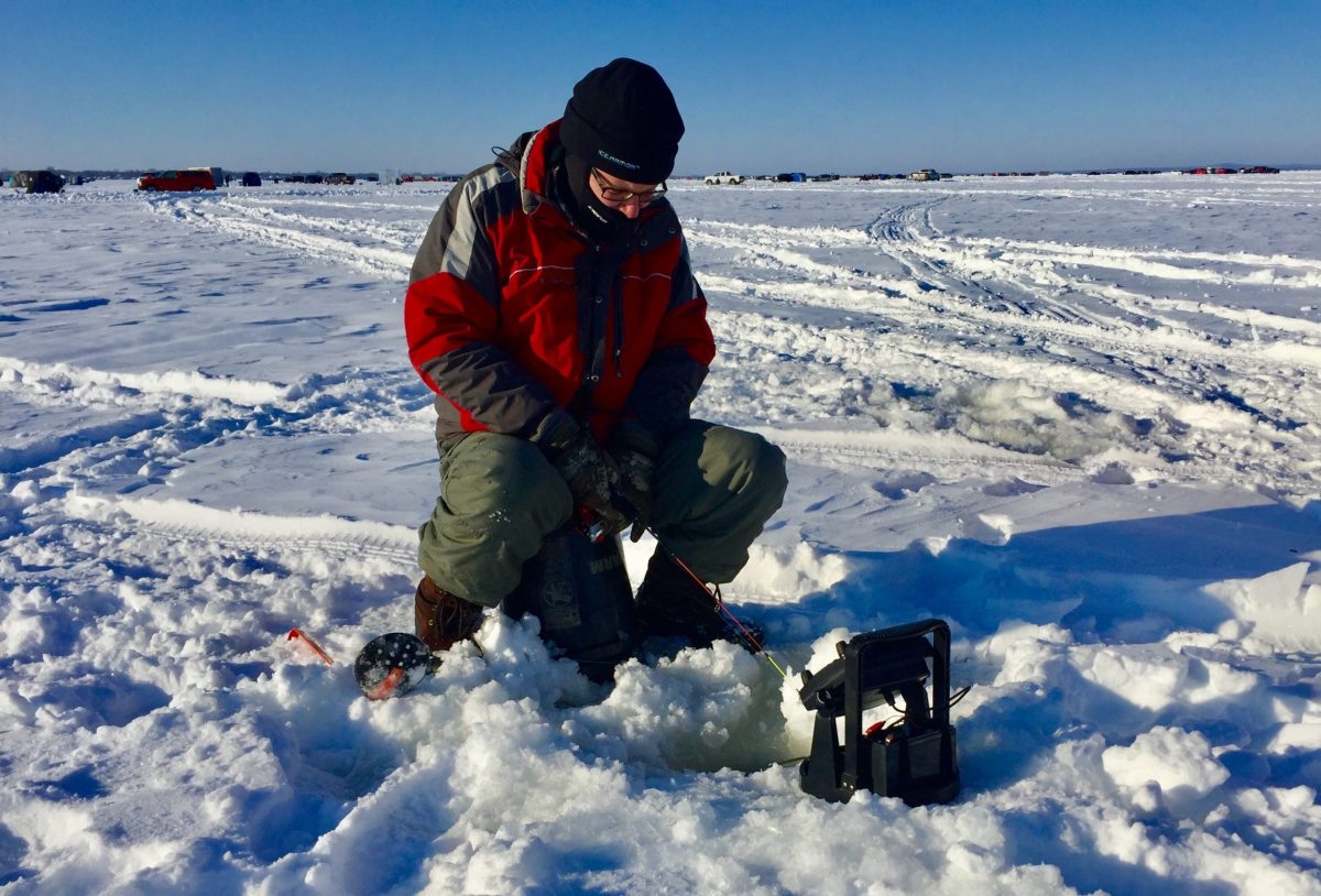 man sitting on ice fishing