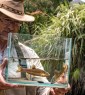 man in a hat holding a fish tank with a fish inside
