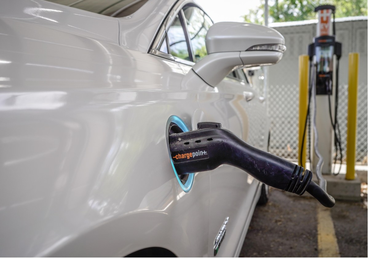 Showing an electric car plugged into a charger