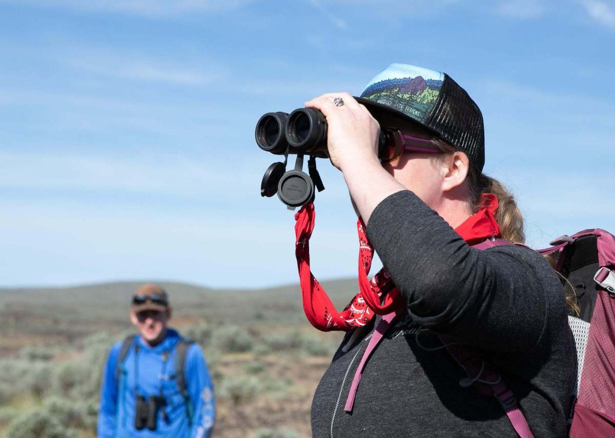 woman holding binoculars to her face