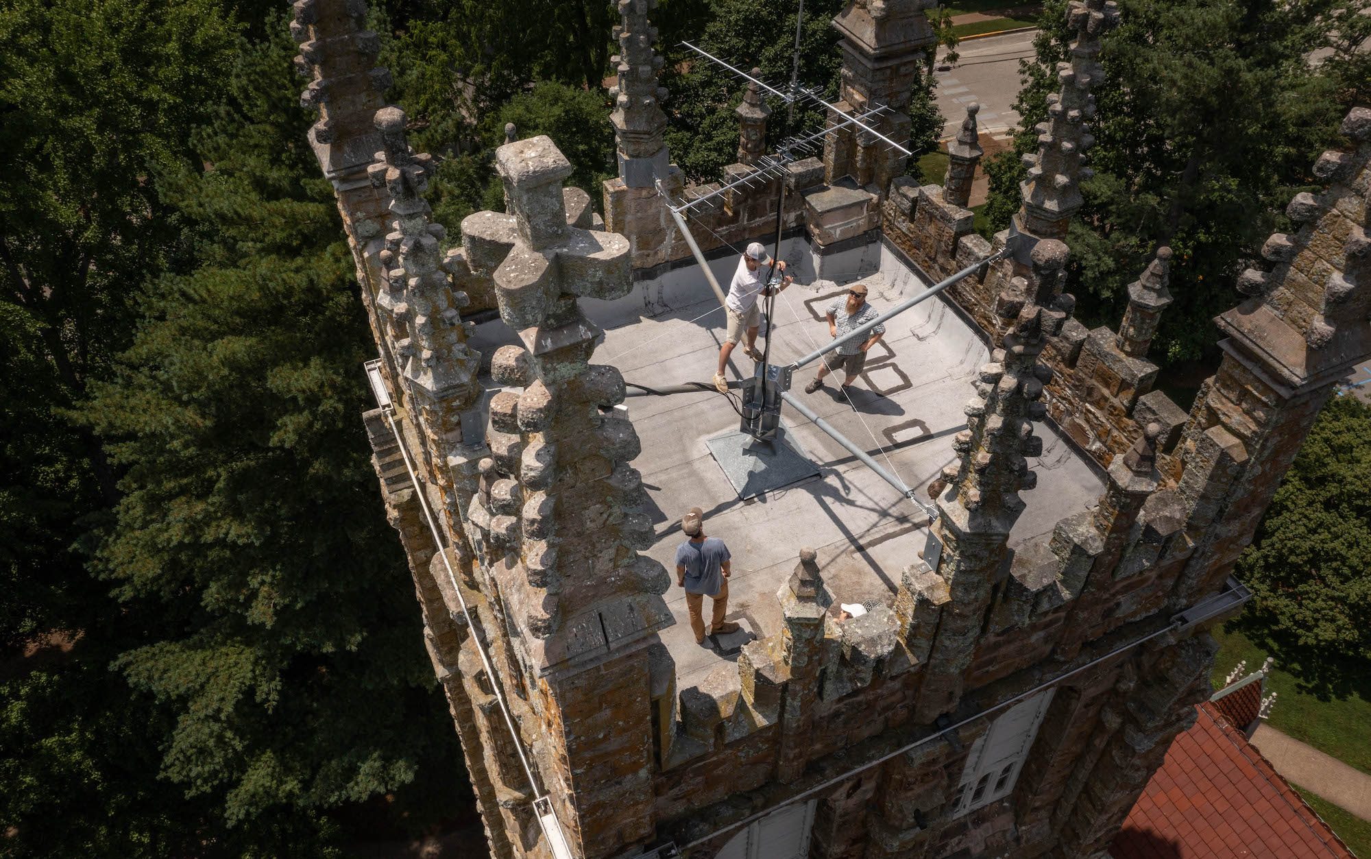 people standing on top of a building with equipment