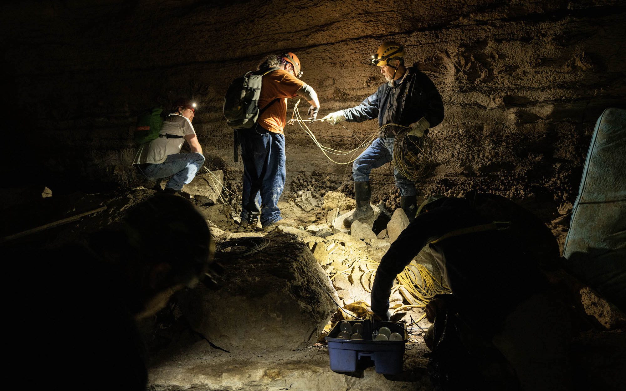 people standing inside a cave with lights and photography equiptment