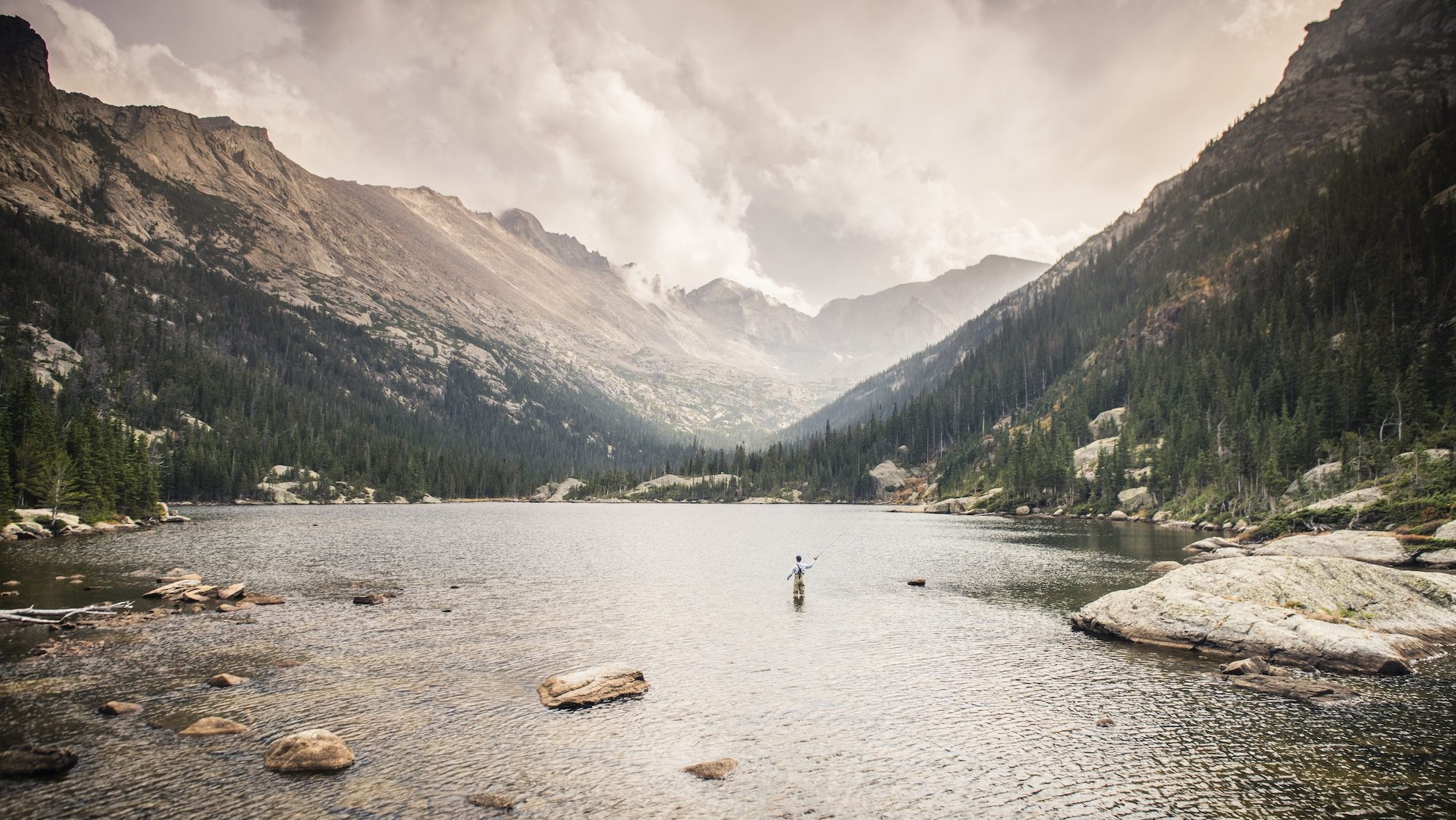 person fishing in a mountain lake