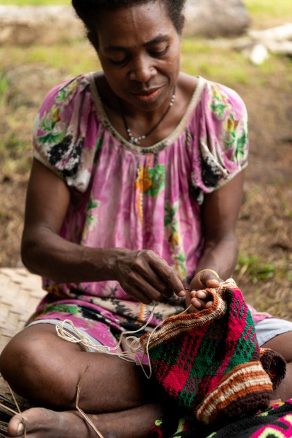 A woman weaving a bag