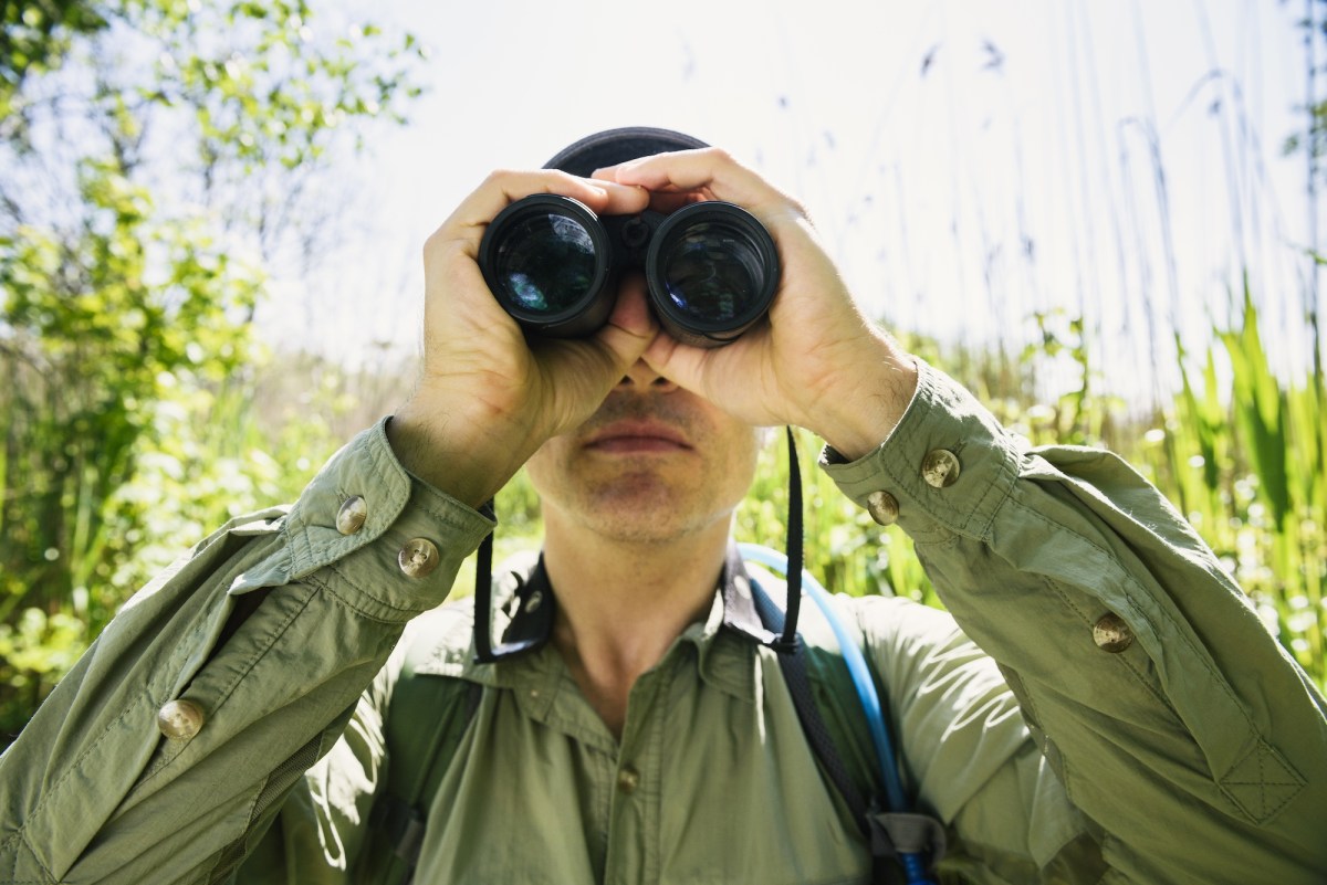 man holding birdculars to his face