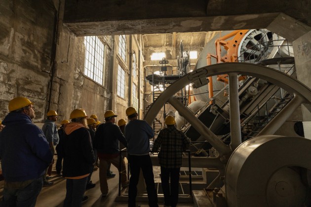 people in hard hats standing inside a mine