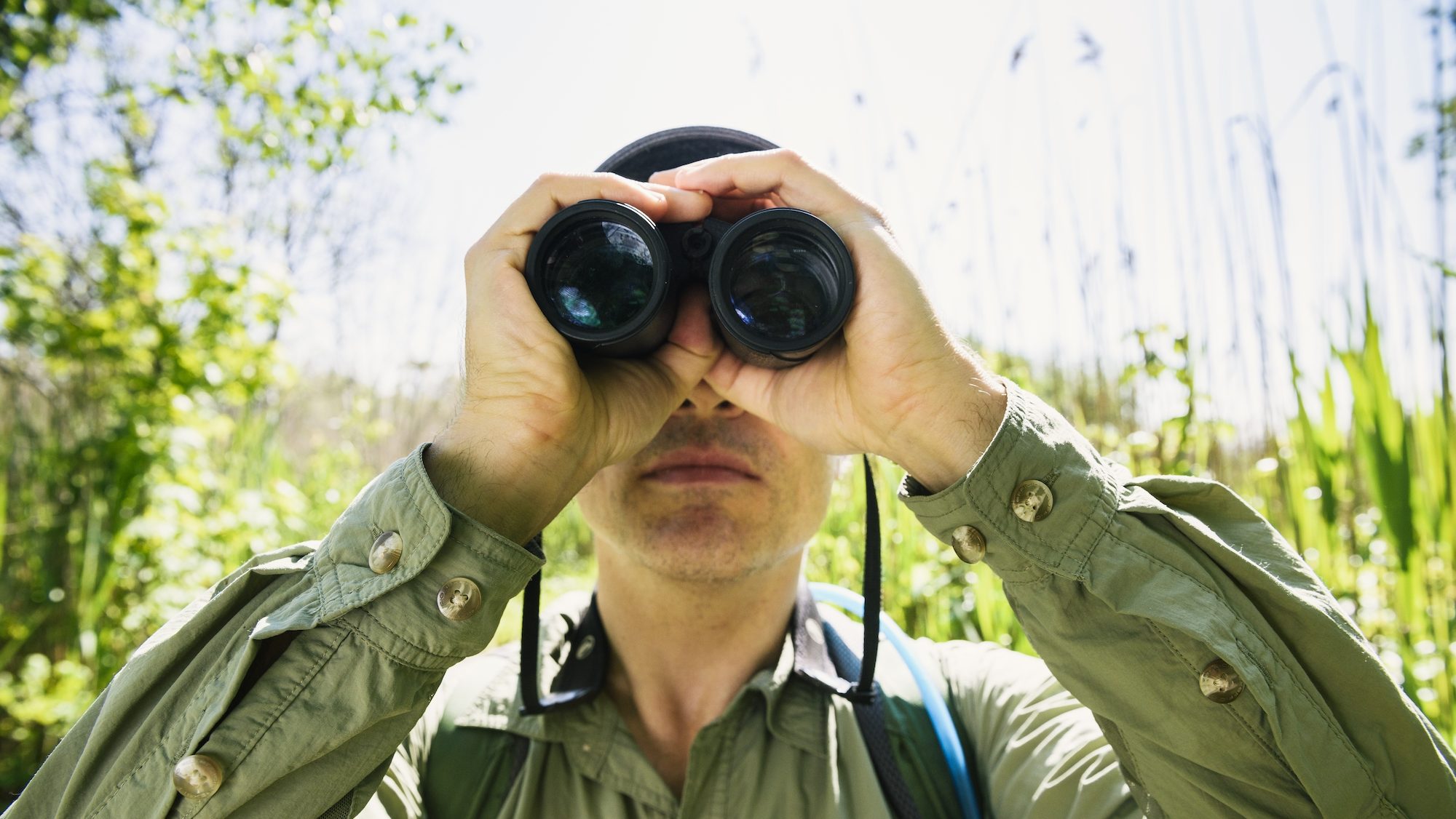 man holding birdculars to his face