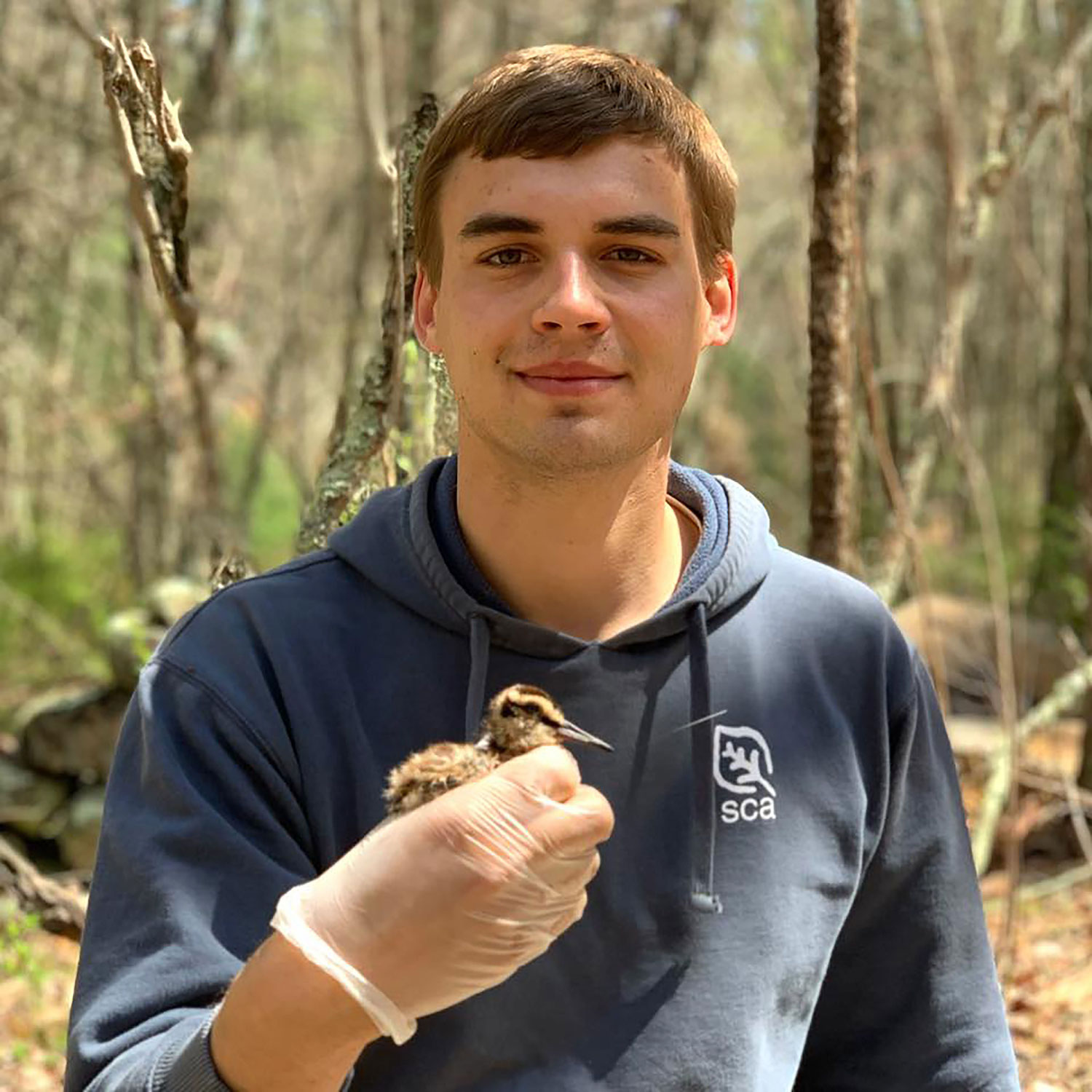 young man holding a small chick