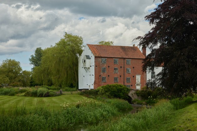 A red and white building next to a stream.