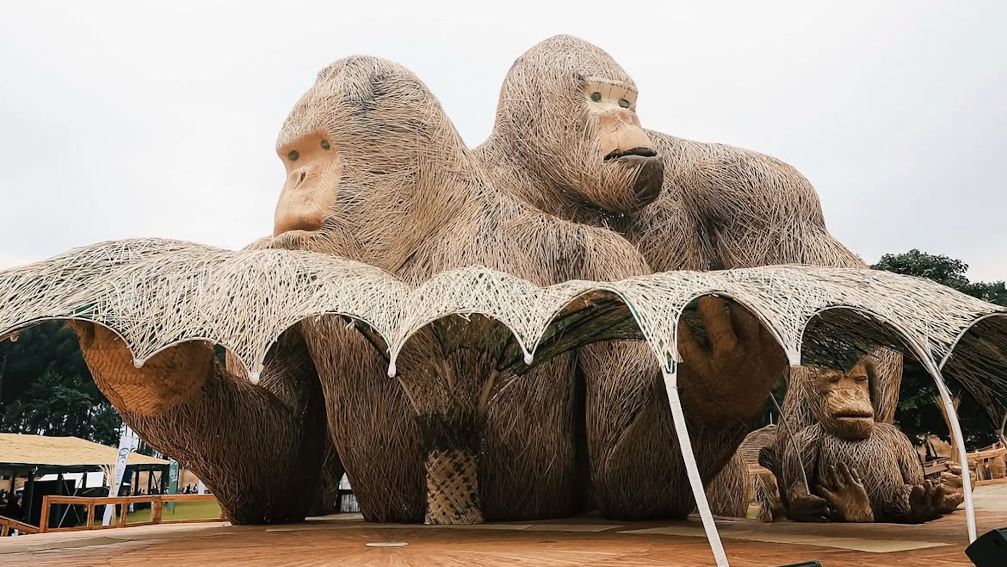 A very tall sculpture, made from woven bamboo, of two gorillas. 
