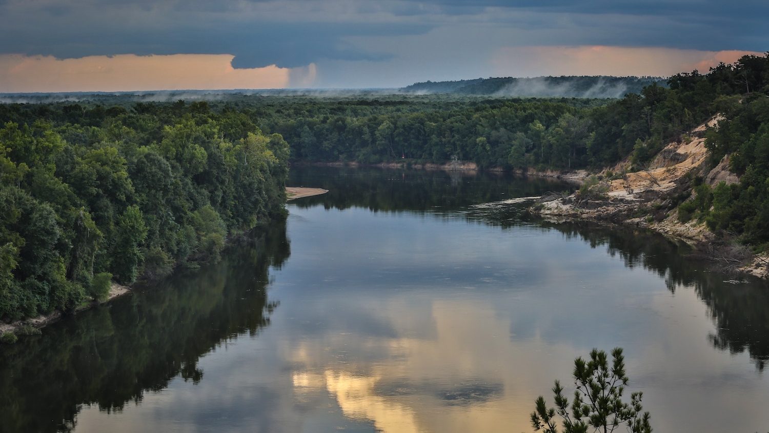 A landscape view of a river with sandy bluffs.