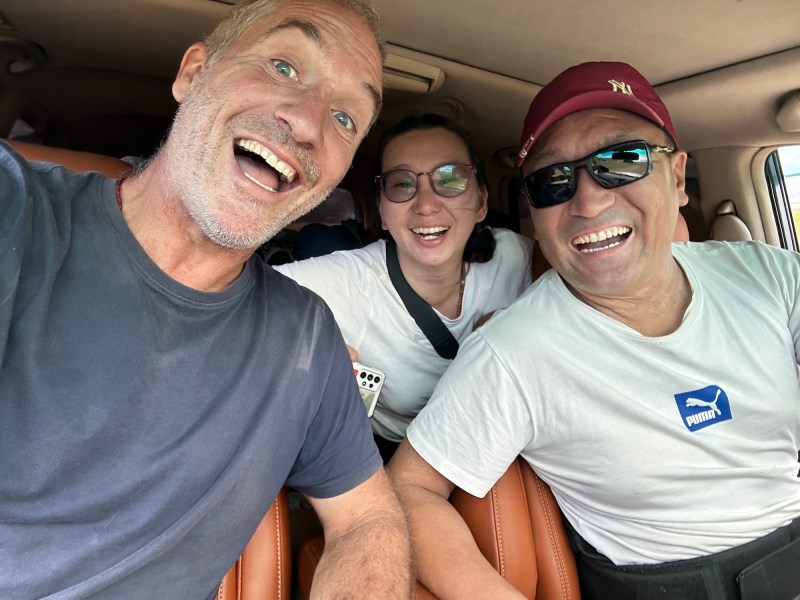 Two men and a woman smiling into the camera for a selfie. 