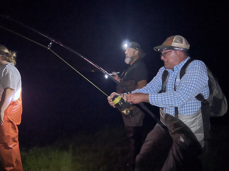 Man with a fishing rod in the dark